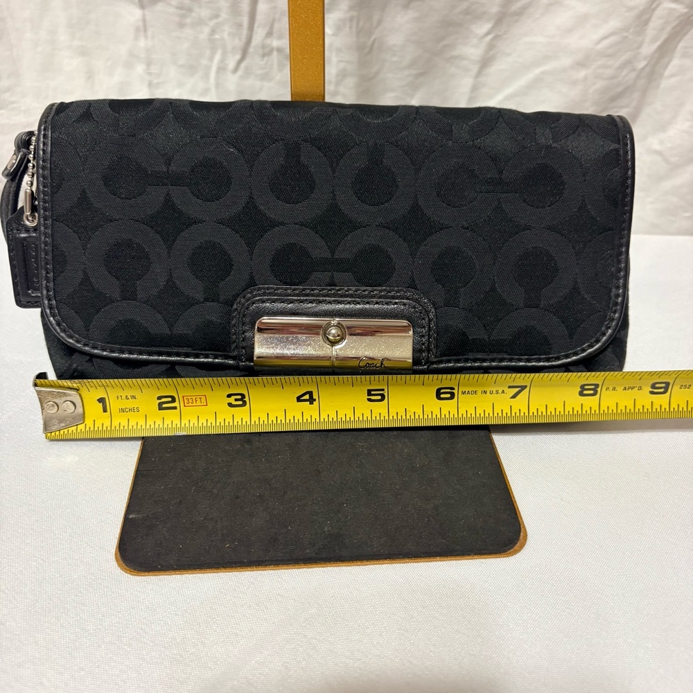Black clutch wristlet, likely featuring silver-tone hardware - Picture 4 of 7